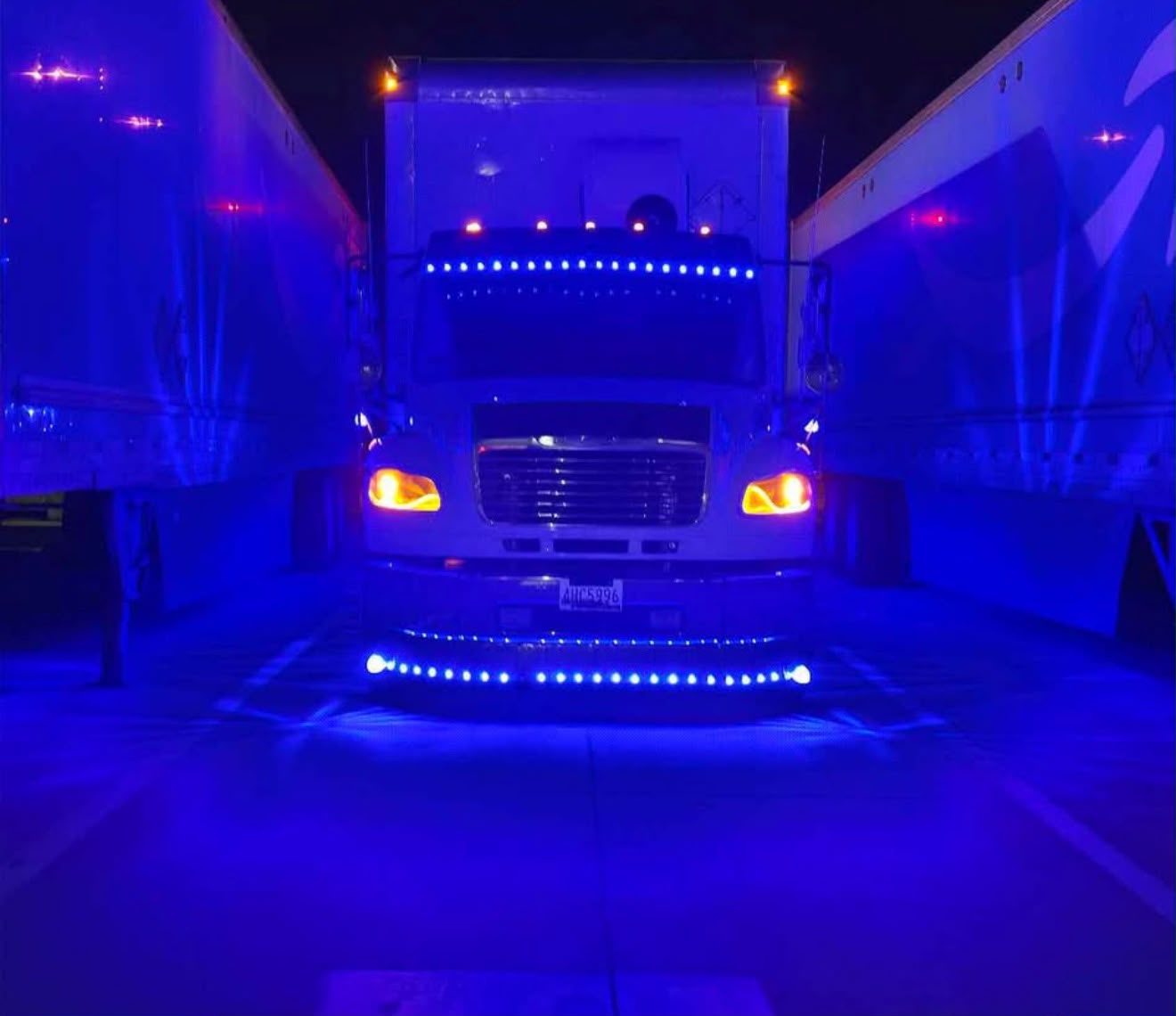 Box truck de FreightPenn estacionado entre trailers de noche